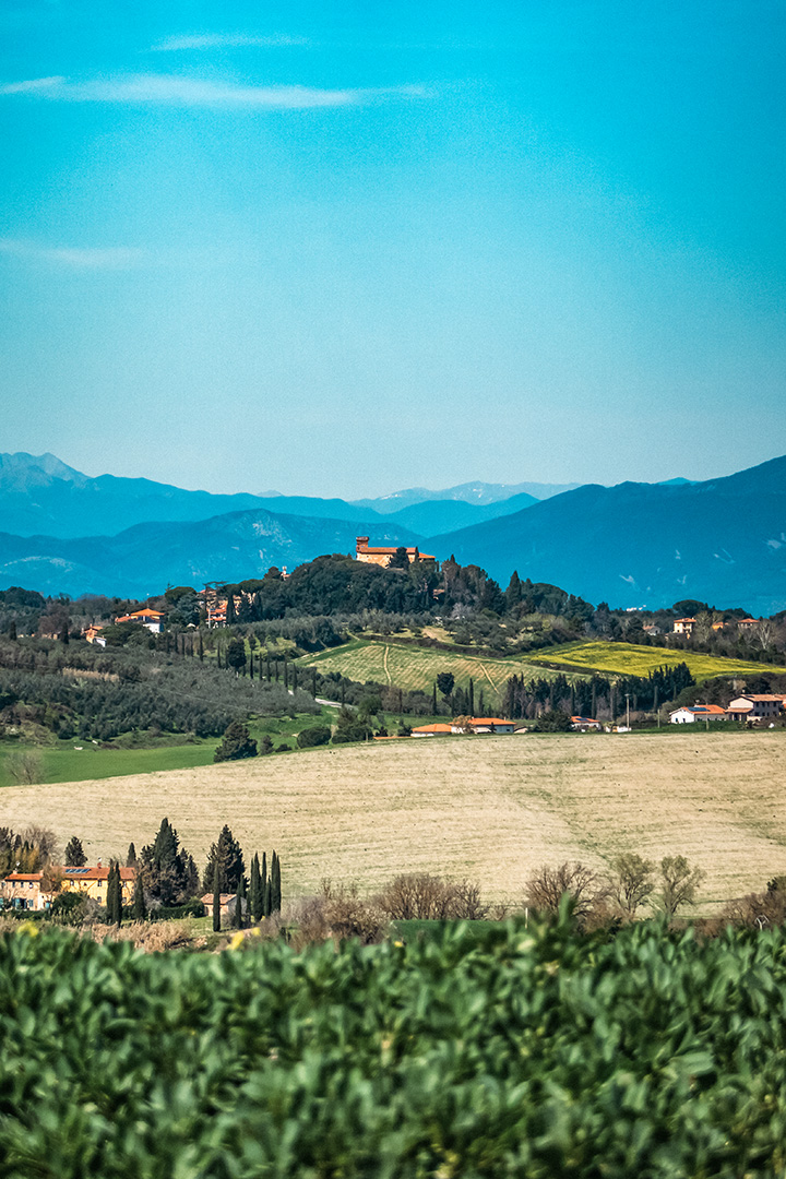 Splendida vista panoramica sulle colline toscane con borghi storici e cipressi, facilmente raggiungibili dalla tenuta.