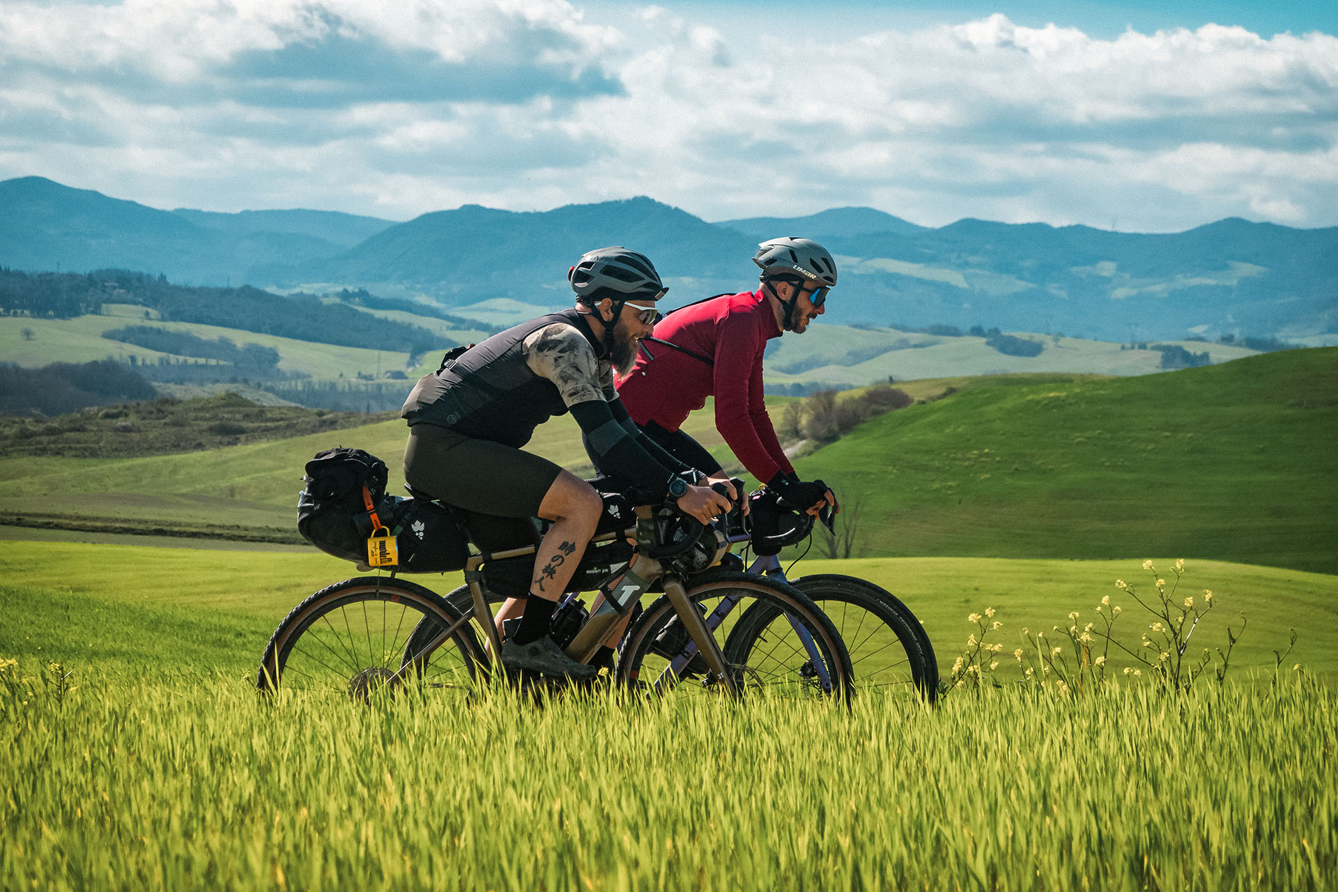 Due ciclisti che esplorano i sentieri panoramici e le colline verdi vicino a Poggio al Casone durante un tour guidato in bicicletta.
