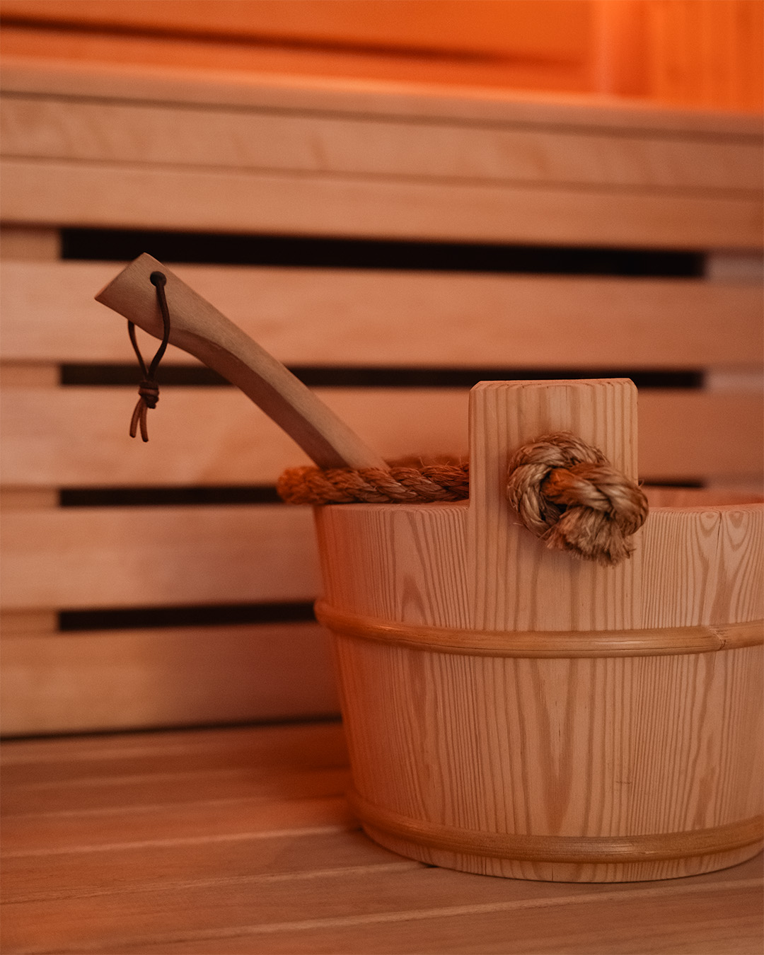 Dettaglio dell'area benessere con secchiello in legno per sauna, parte dell'offerta wellness esclusiva di Poggio al Casone.